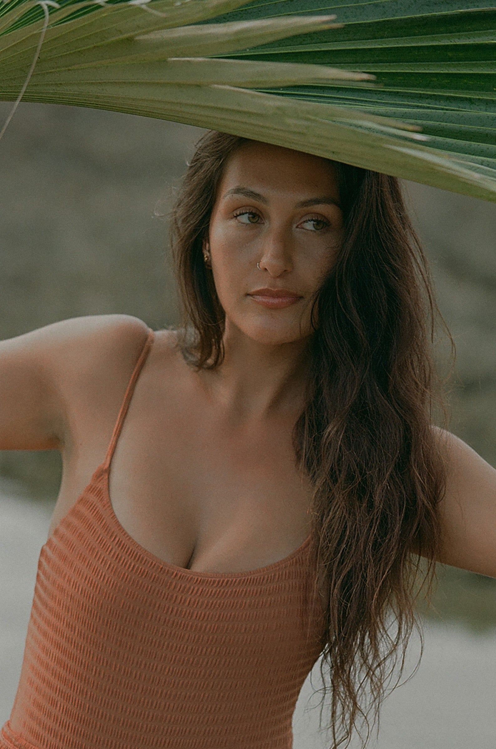 girl under palm leaf at beach