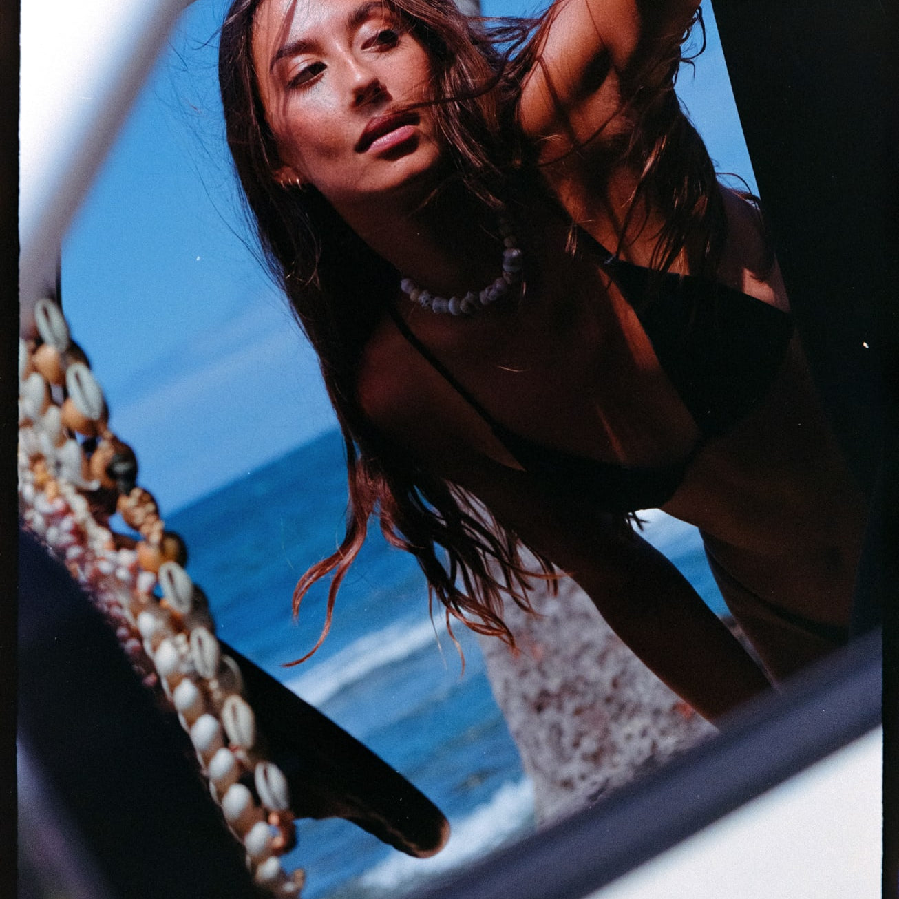 girl leaning on truck looking to the side in bikini