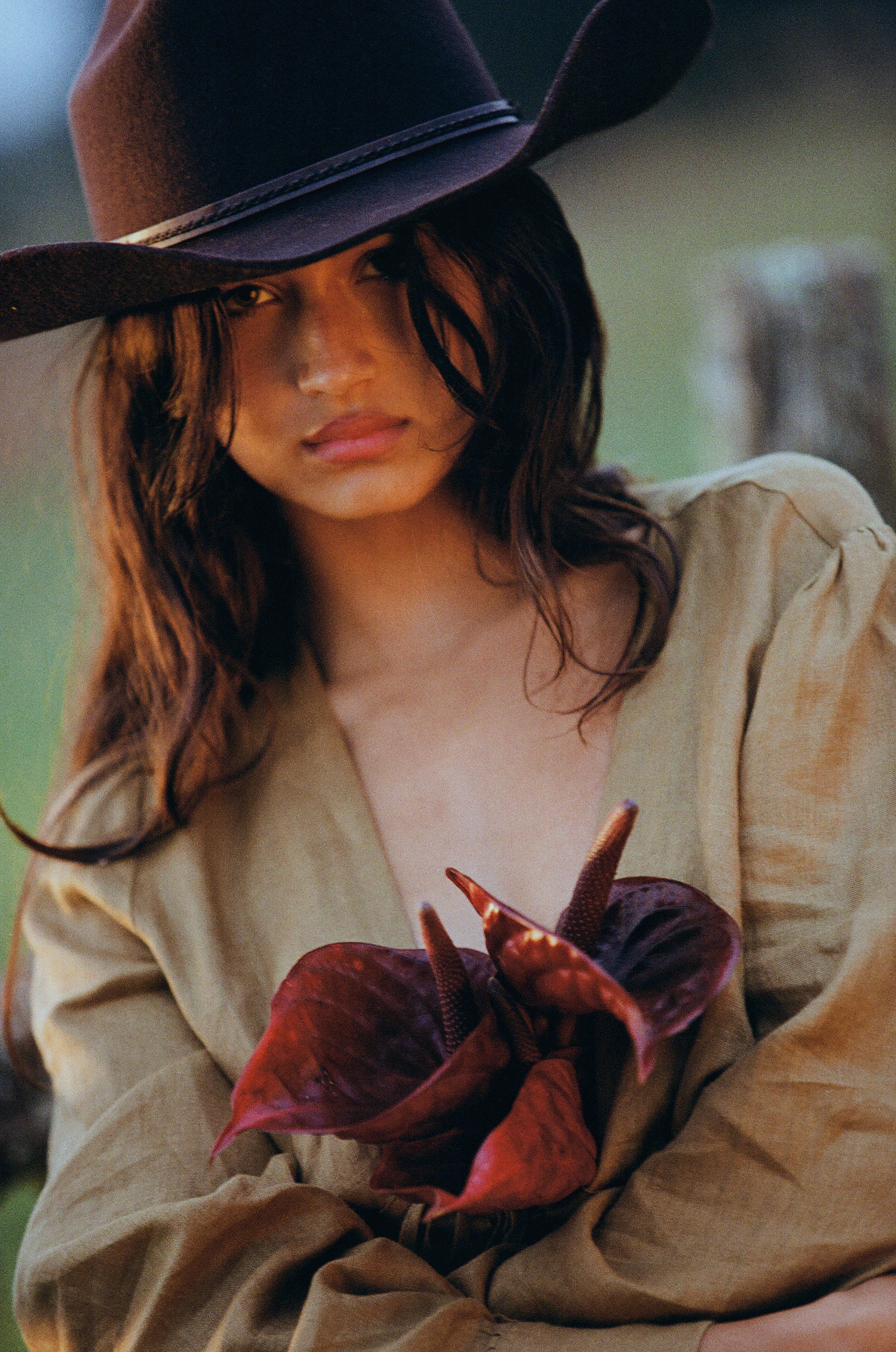 girl in linen blouse with flowers in cowboy hat