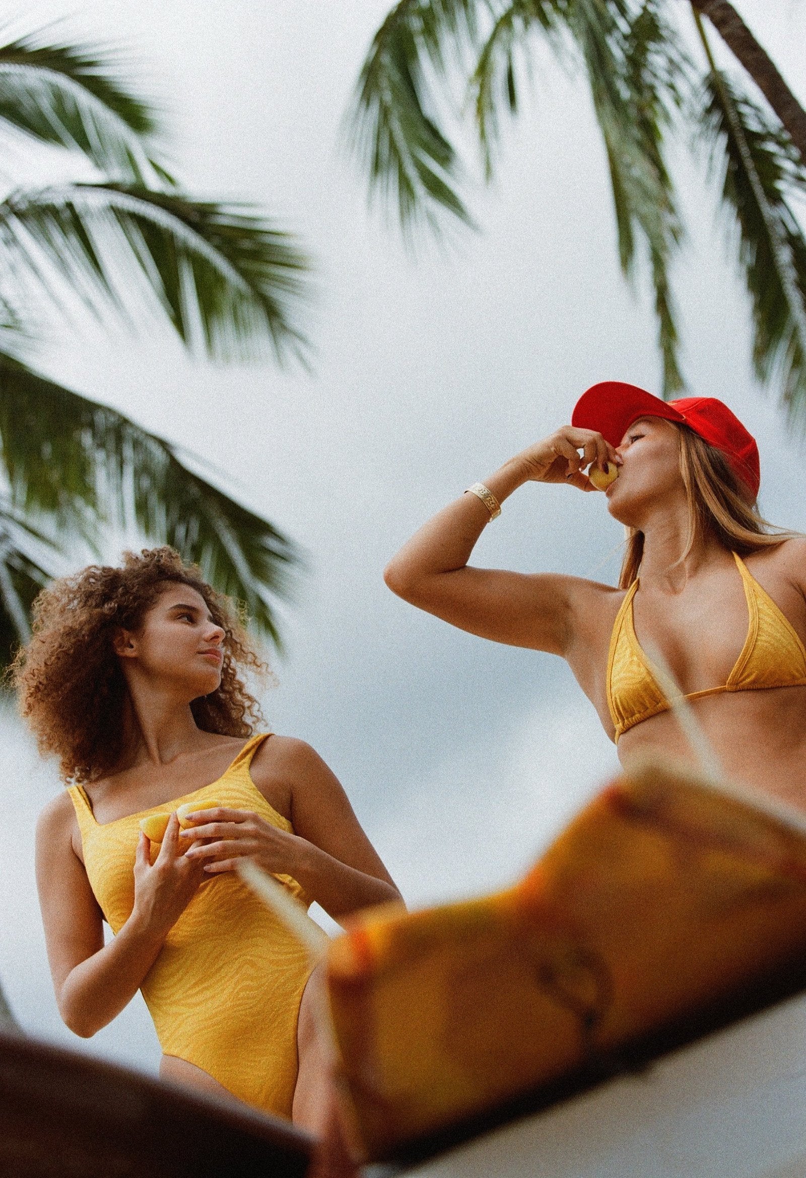 girls eating lilikoi in yellow bikinis in back of truck