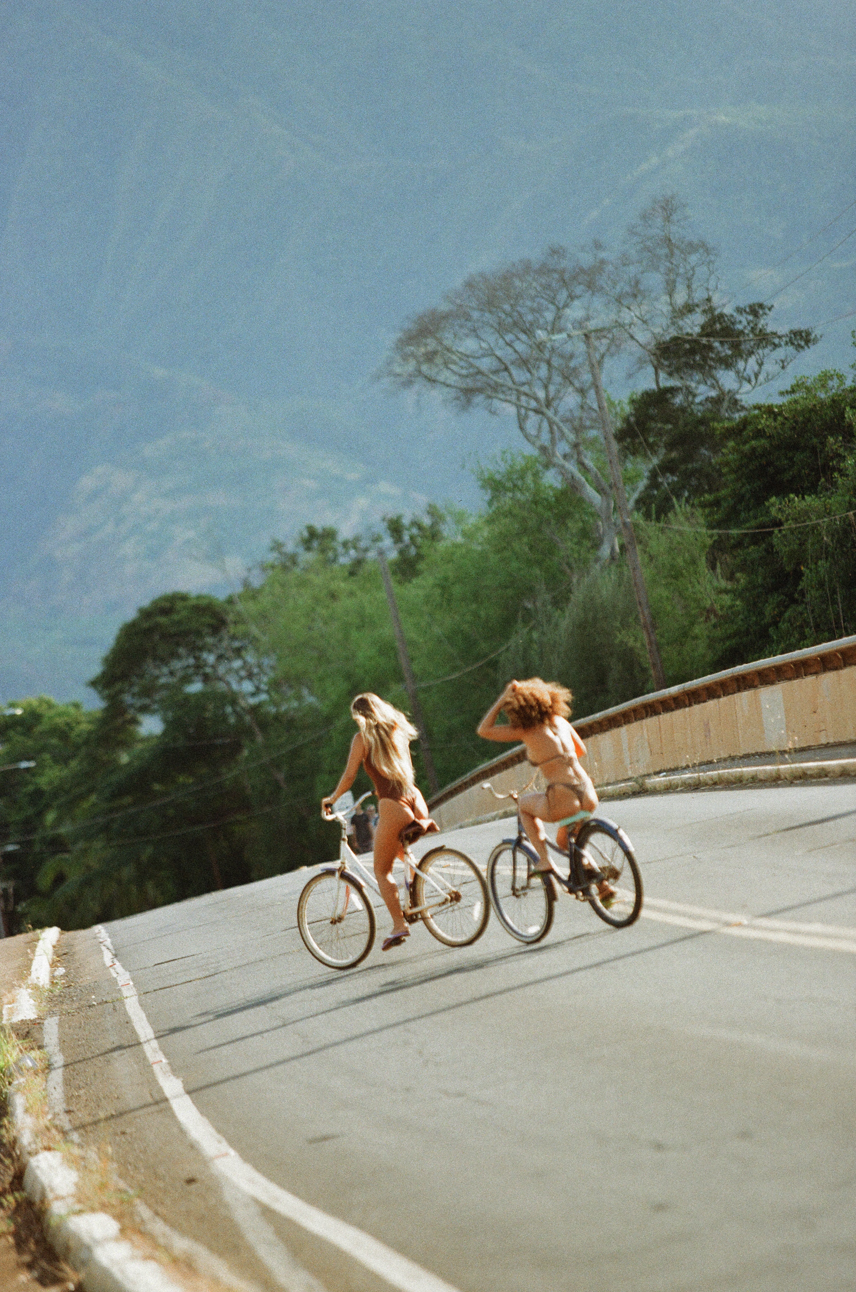 girls riding bike across the road
