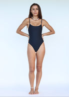 Woman wearing a black swimsuit on a light blue background