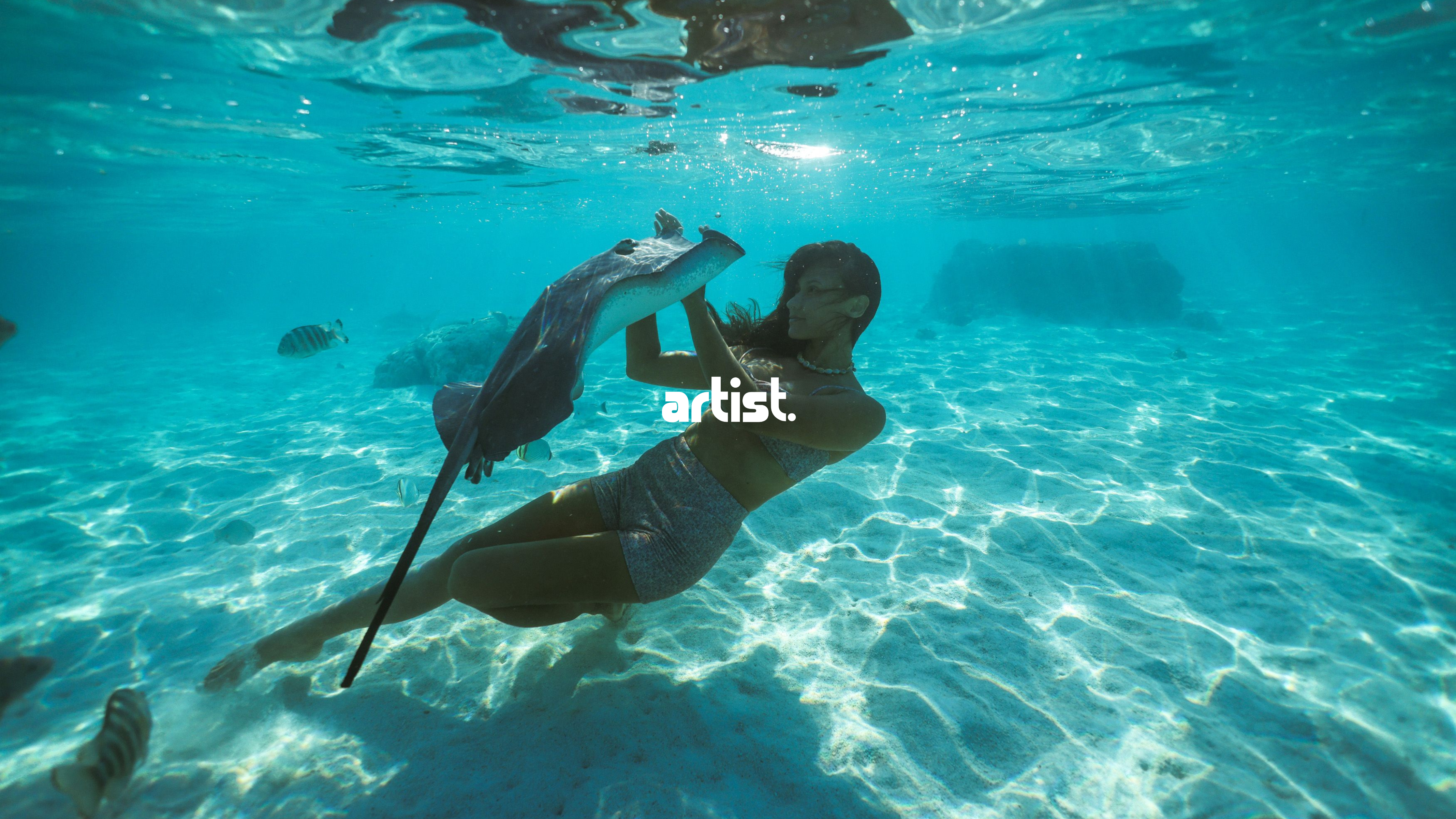 girl swimming underwater with stingray