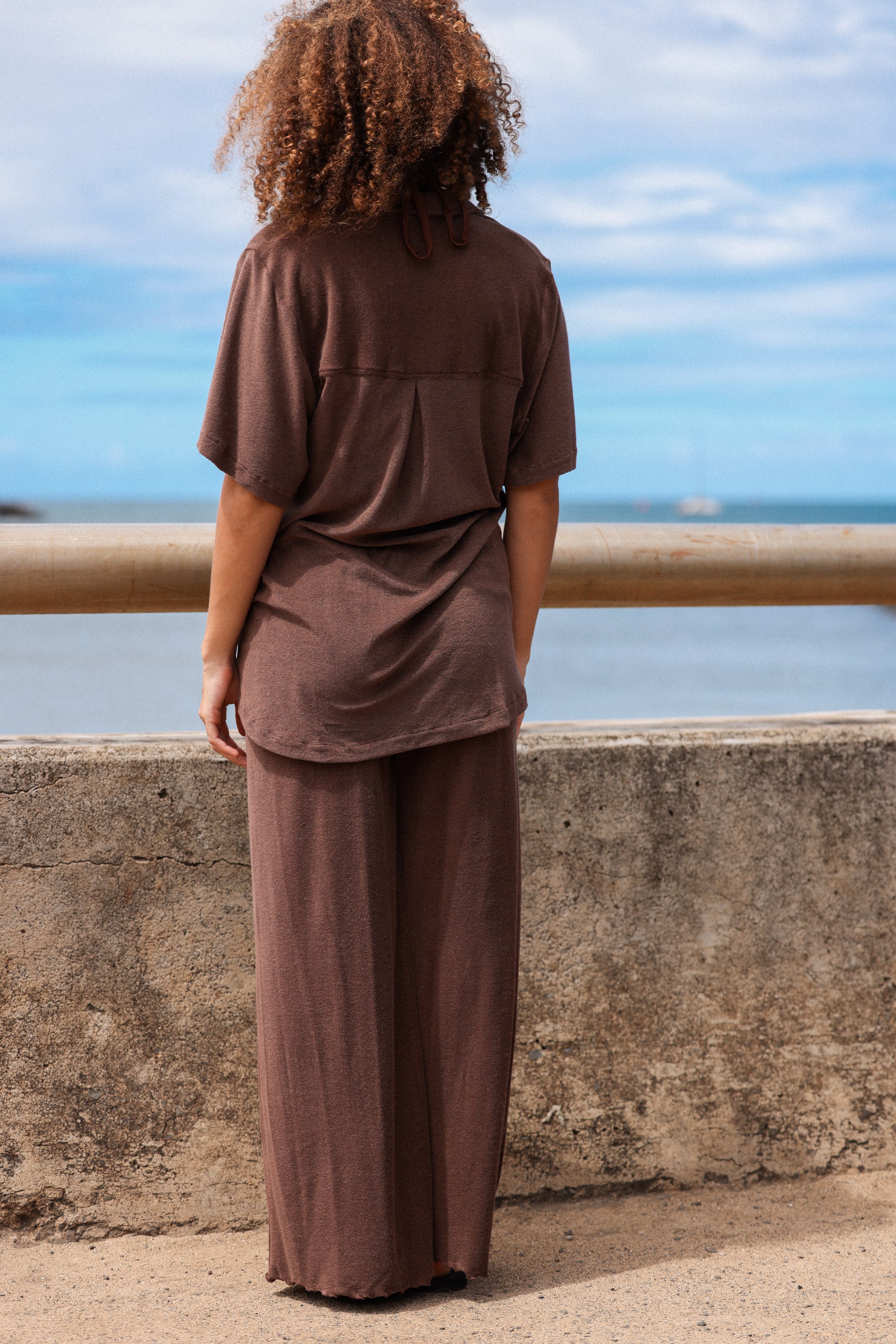 girl standing looking out at water in matching brown set in eco terry